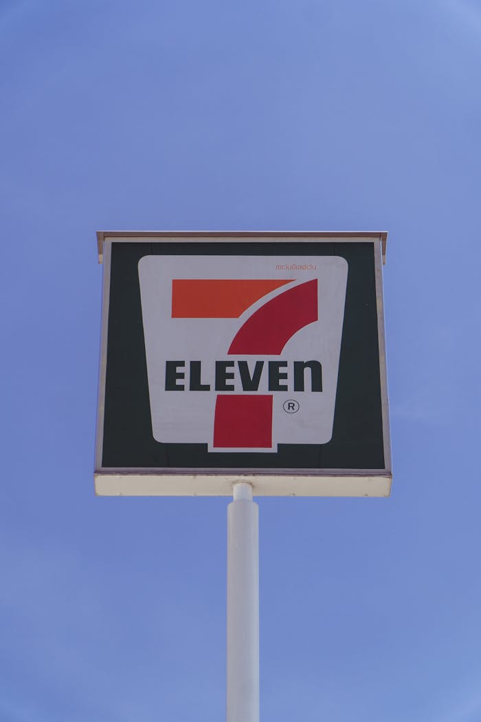 services-02 Photo of a 7-Eleven store sign against a bright blue sky, symbolizing convenience.